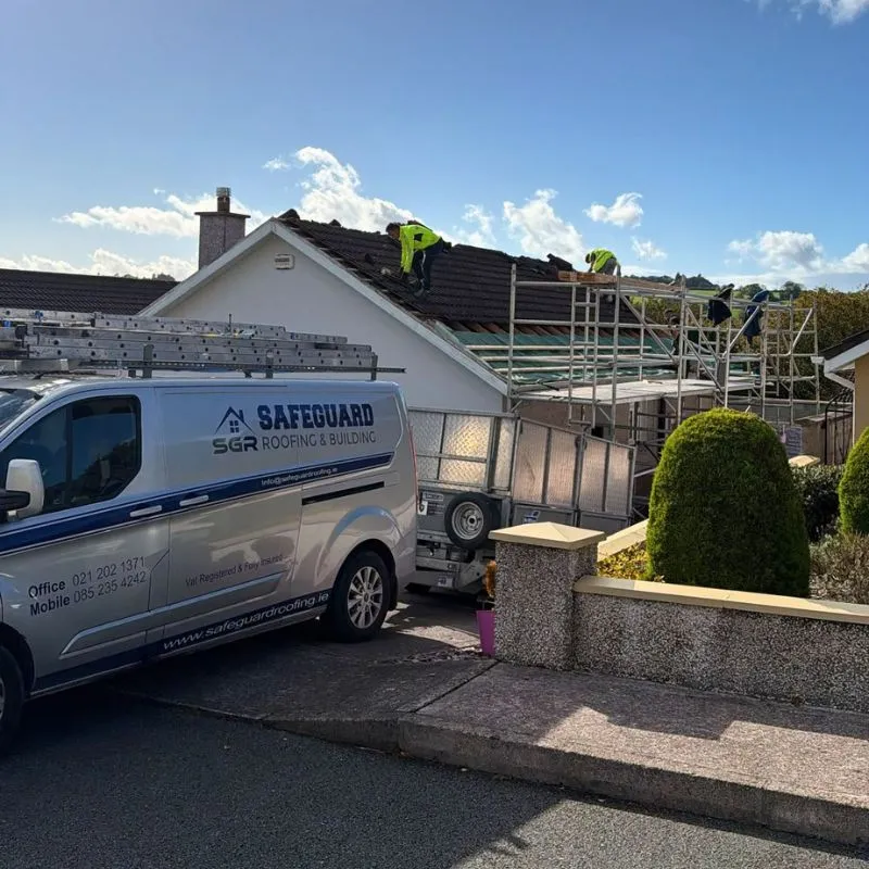 Safeguard van beside scaffolding and roofers working on a pitched roof in Glanmire